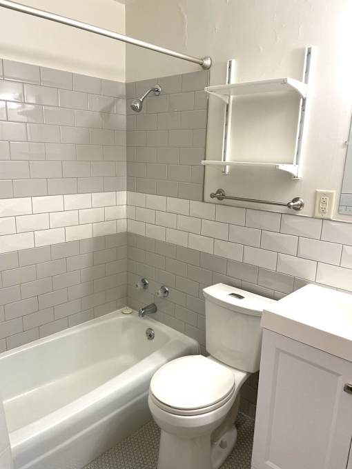 A white toilet sits next to a bathtub in a bathroom.