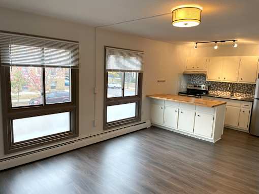 A kitchen with white cabinets and a wooden island.