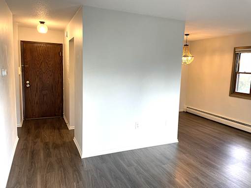 A room with a wooden door and a window.
