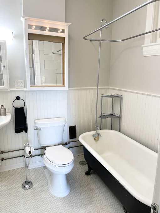 A white toilet sits next to a white bathtub in a bathroom.