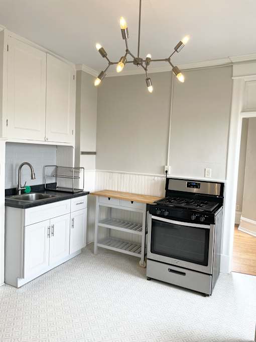 A modern kitchen with a black stove top oven and white cabinets.