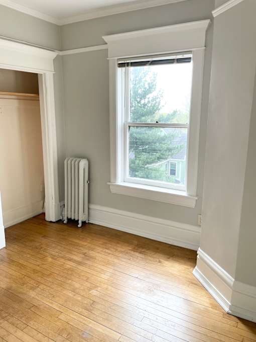 A room with a window and a radiator on the wall.