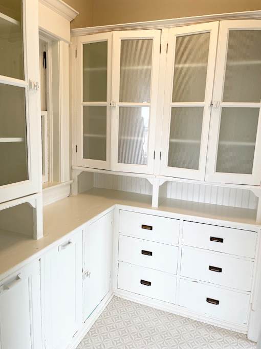 A kitchen with white cabinets and drawers.