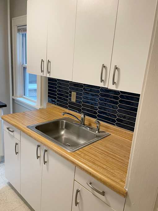Updated kitchen includes decorative tiled backsplash, some new cabinetry and countertops.