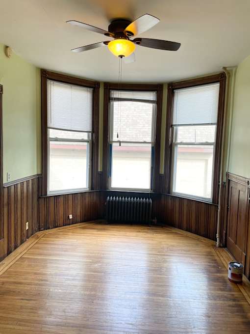 Large main room of a grand scale - with bowed windows and 11' ceilings.