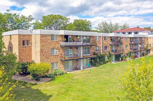 A large apartment complex with a green lawn in front.