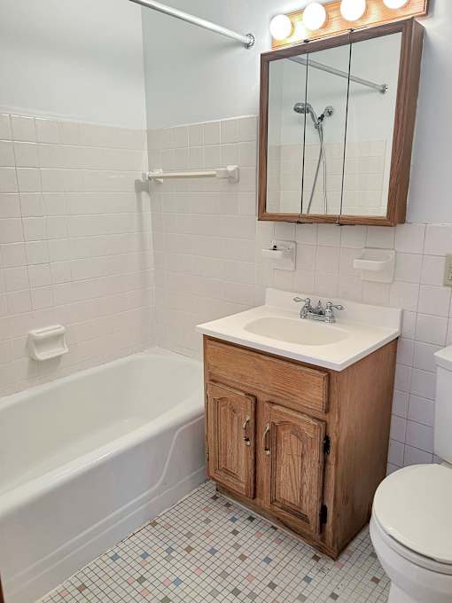 A white sink is on a wooden cabinet in a bathroom.