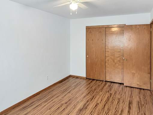 A room with a wooden floor and a wooden wardrobe.