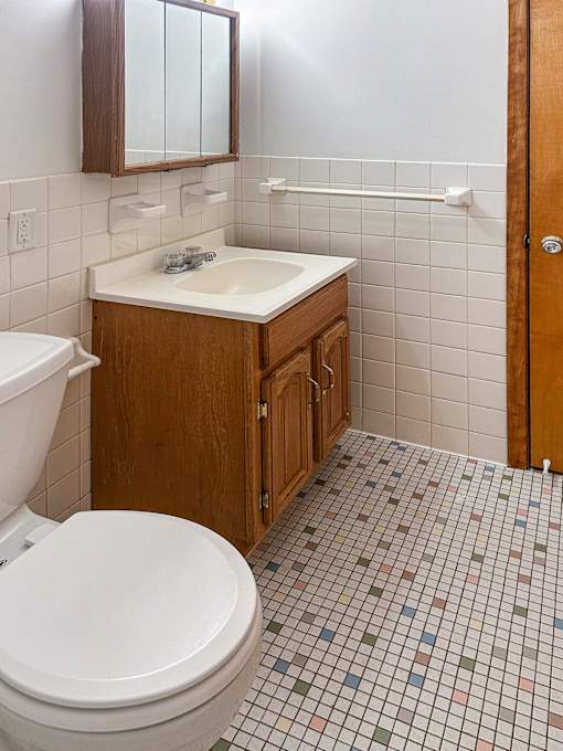 A white toilet sits next to a sink in a small bathroom.
