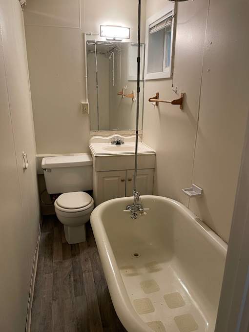 A white bathroom with a white toilet, sink, and bathtub.
