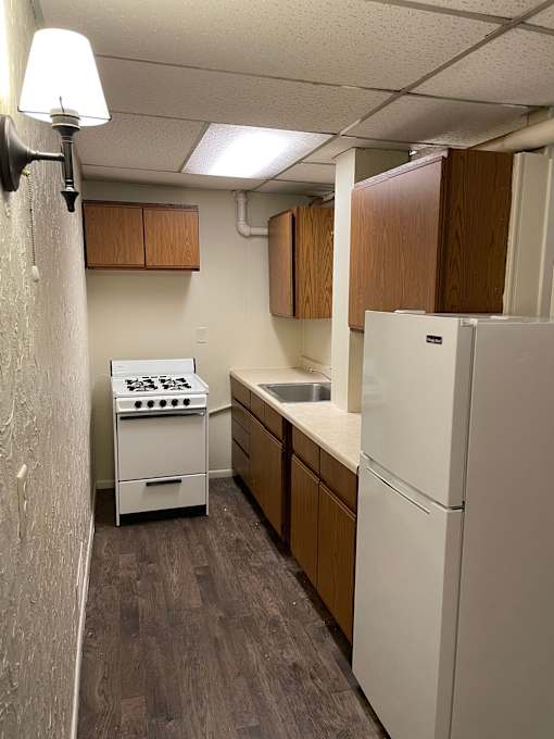 A small kitchen with a white refrigerator and a white stove.
