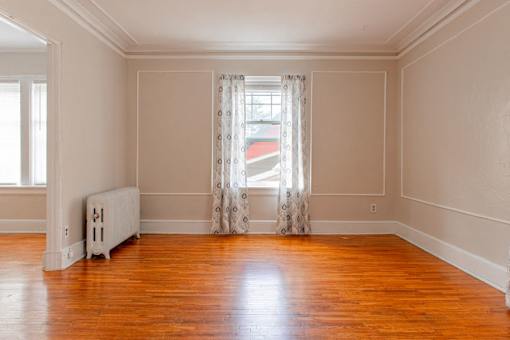 A room with wooden floors and a white radiator.