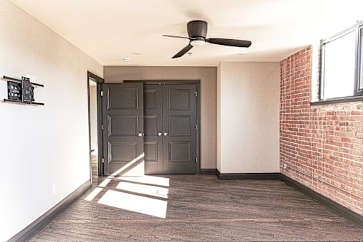 A room with a ceiling fan and a large door.