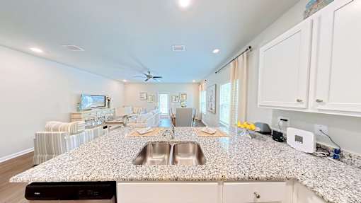 A kitchen with a granite countertop and a fan on the ceiling.