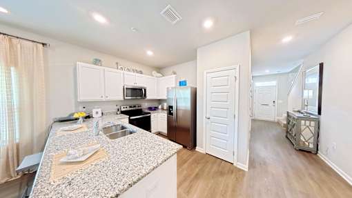 A kitchen with granite countertops and white cabinets.