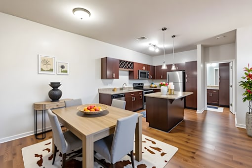 A modern kitchen with a wooden dining table and chairs.
