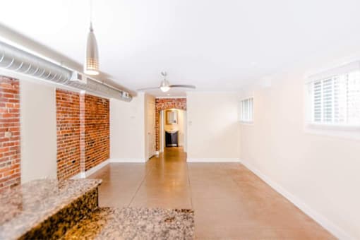 A room with a brick wall and a ceiling fan.