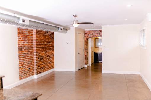 A room with a brick wall and a ceiling fan.