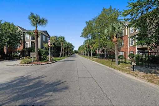 A tree-lined street with a row of houses on either side.