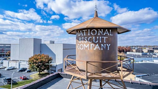 A large sign for the National Biscuit Company stands in front of a building.