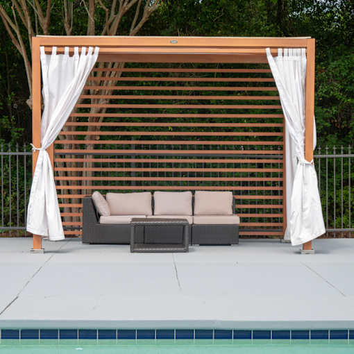 A poolside lounge area with a white canopy and a brown lattice backdrop.