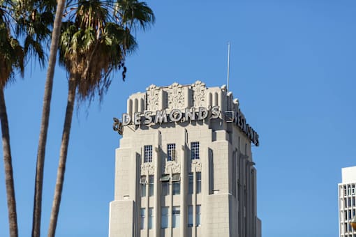A tall building with palm trees in front of it.