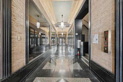 A long hallway with a shiny floor and a wall on the side.