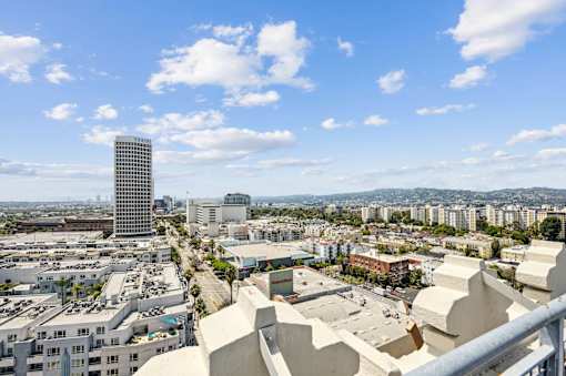 A cityscape with a mix of modern and older buildings under a clear sky.
