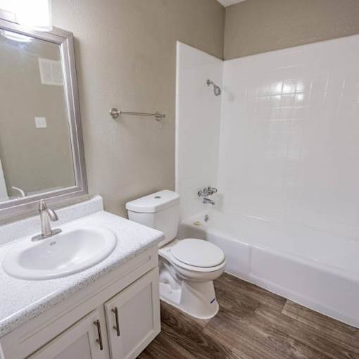A white toilet sits next to a white sink in a bathroom.