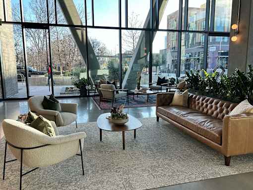 A living room with a large window and a view of the city.
