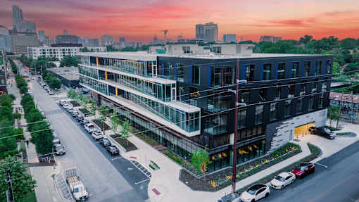 A modern building with a parking lot in front of it.