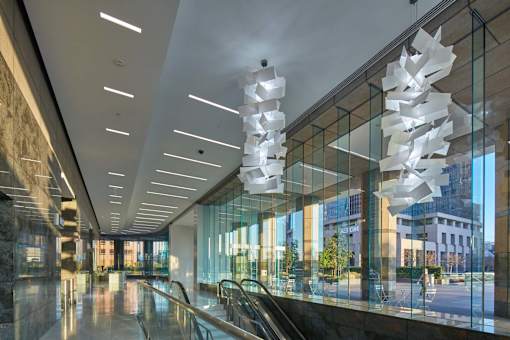 A modern hallway with a glass wall and a staircase.