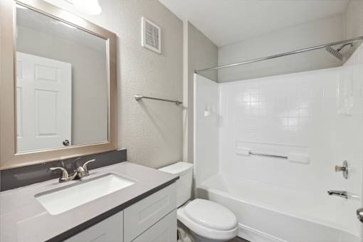 A white toilet sits next to a sink in a bathroom.