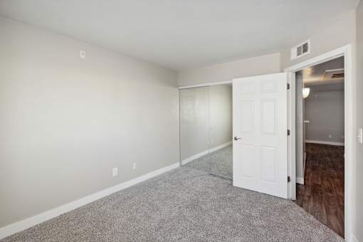 A room with a white door and carpeted floor.