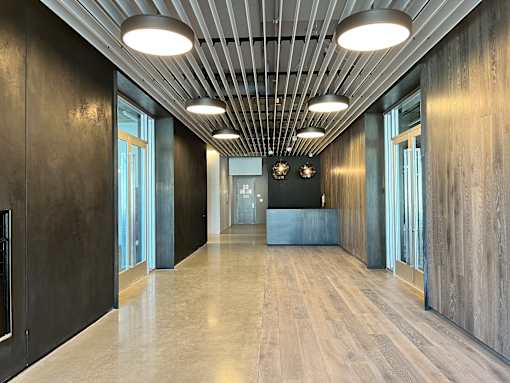 A long hallway with wood floors and ceiling lights.