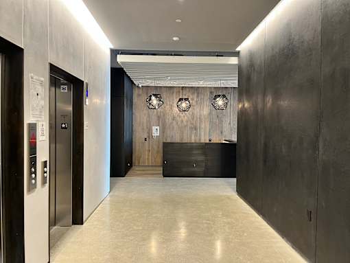 A hallway with a black wall and a white door.