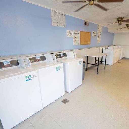 A room with washing machines and a table.