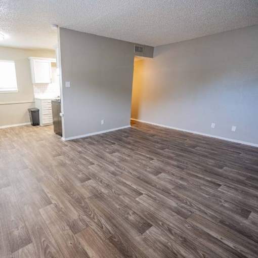 A room with wooden flooring and a white wall.