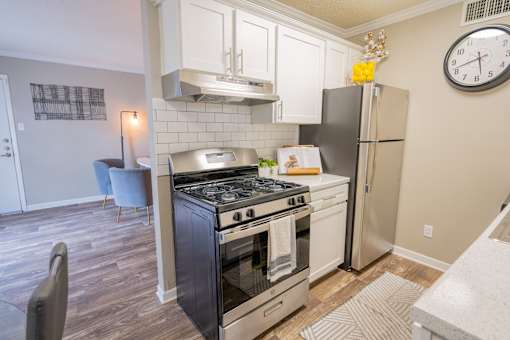 A kitchen with a stove and refrigerator.