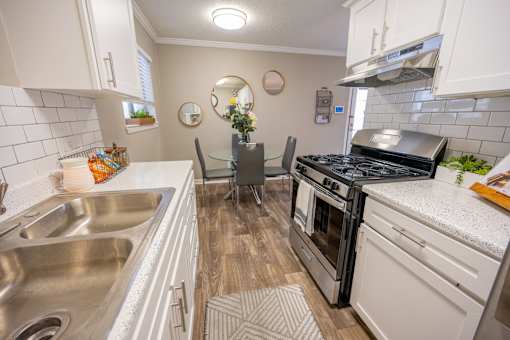 A kitchen with a stove top oven and a sink.