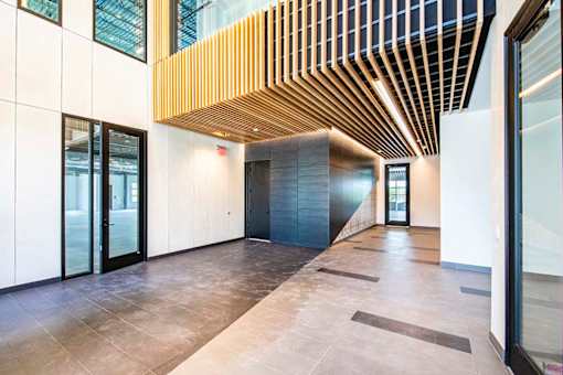 A long hallway with a wooden ceiling and tile flooring.