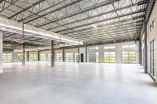 A large, empty warehouse with a high ceiling and large windows.