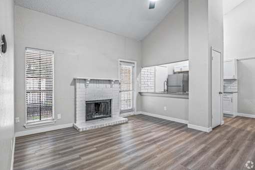 A living room with a fireplace and wooden floors.