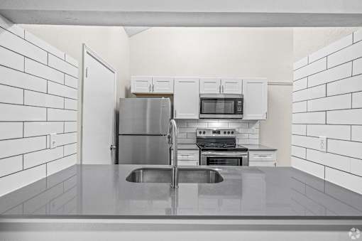 A kitchen with white cabinets and appliances.