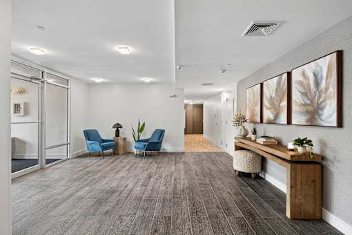 A waiting room with blue chairs and a wooden bench.