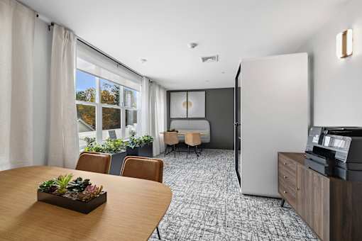 A dining room with a table, chairs, and a window overlooking a garden.