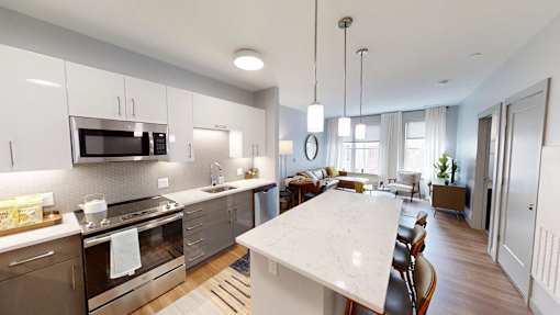 A modern kitchen with a white marble island and stainless steel appliances.