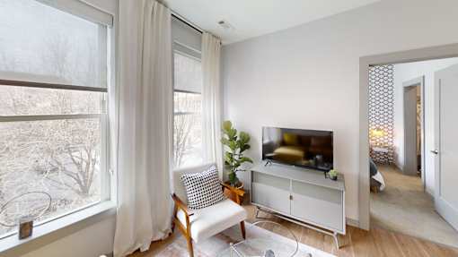 A living room with a television and a chair.