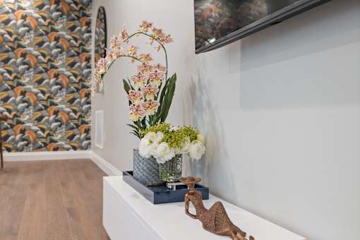 A room with a white bench and a sculpture of a giraffe.