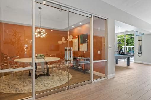 A glass door with a table and chairs inside.